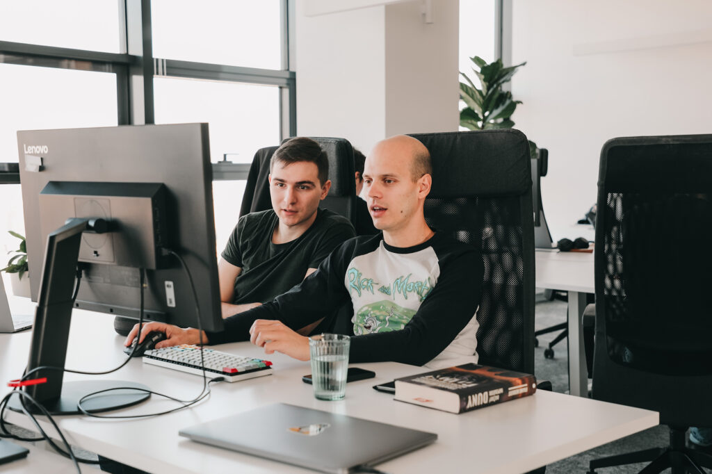 two male software engineers collaborating on a computer