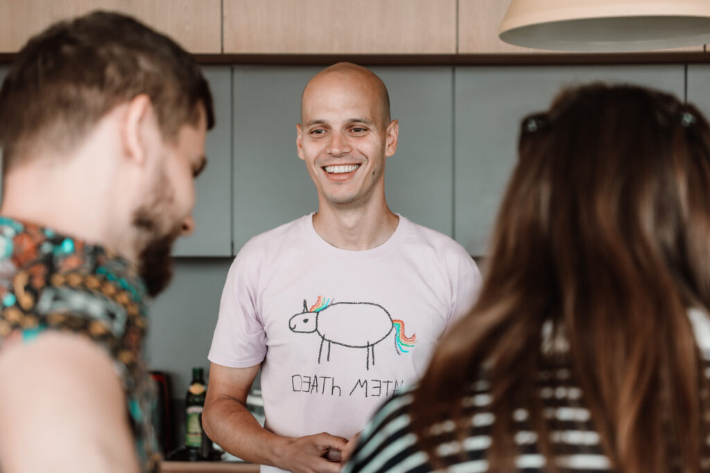 a detail on a smiling man with a pink death metal tshirt on