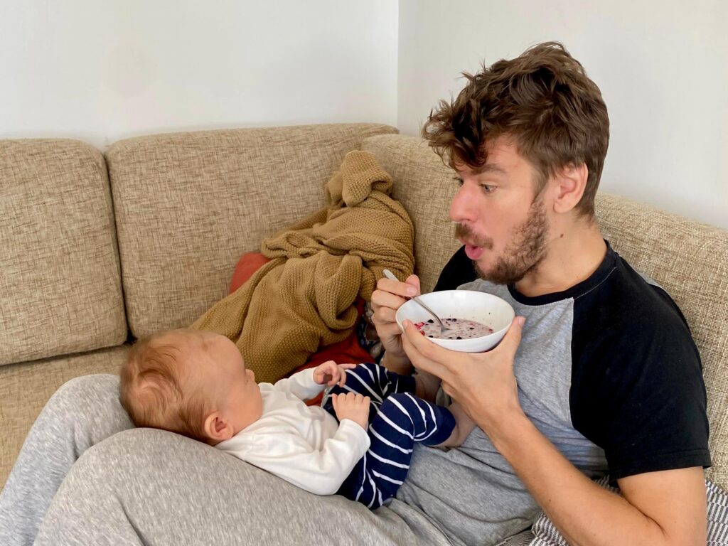 a man with his baby son eating his breakfast