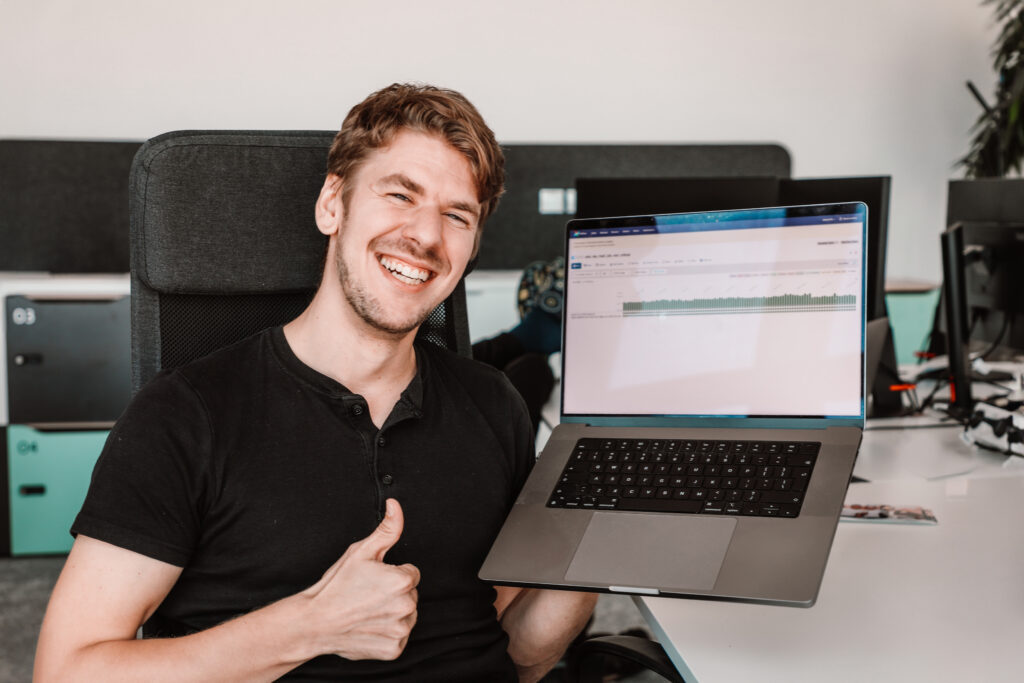 a male data engineer smiling with his laptop